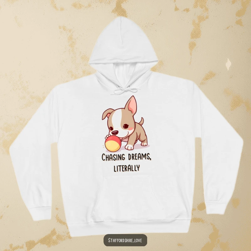 Funny Kawaii Staffordshire Bull Terrier puppy hoodie, adorably chasing a squeaky toy, radiating pure, unadulterated puppy joy.